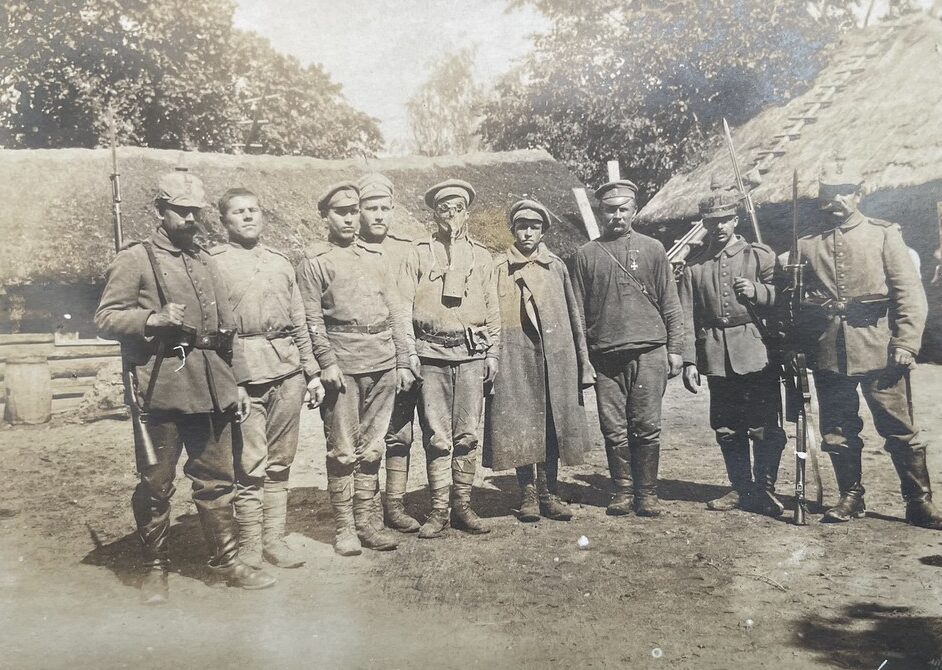 Unbekannter Fotograf, unbekannter Ort an der Ostfront, ca. 1916. Man erkennt 6 gefangene russische Soldaten, die von 3 deutschen Soldaten bewacht werden. Einer der russischen Soldaten trägt eine Gasmaske. Die deutschen Soldaten dürften dem Landwehr-Infanterie-Regiment Nr. 3 und dem Landwehr-Infanterie-Regiment Nr. 379 angehören.
