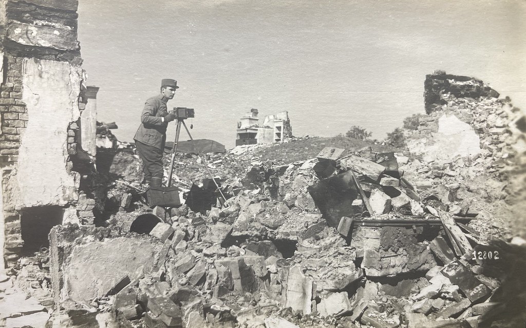 Pragaphot, Prag, 1918. Ein österreichischer Kriegsfotograf steht inmitten von Trümmern und fotografiert diese.